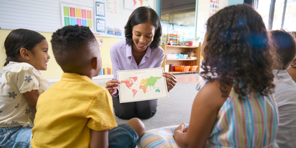 Female Primary Or Elementary School Teacher In Multi-Cultural Class With Map In Geography Lesson Embracing the IB Spirit at FISA: A Journey of Excellence and Identity