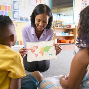 Female Primary Or Elementary School Teacher In Multi-Cultural Class With Map In Geography Lesson Embracing the IB Spirit at FISA: A Journey of Excellence and Identity